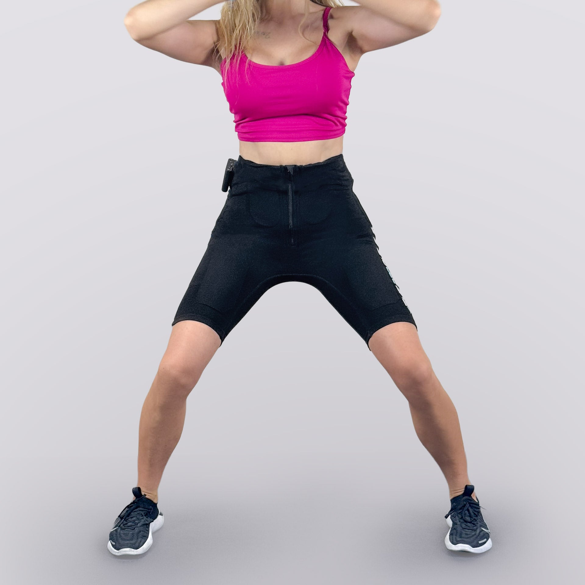 Woman doing wide-stance workout in EMS PRO ONE suit for lower body training